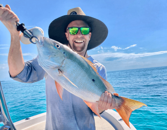 Adult male in hat posing with fish