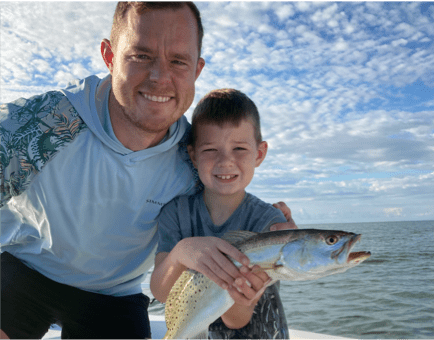 Man and child posing with a Trout